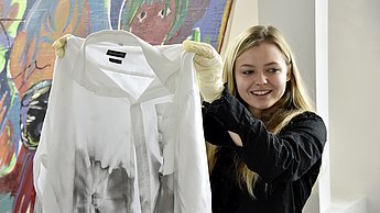Frau hält einen Hoodie hoch