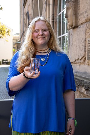 Studentin Marlon Meyer hält das Oechsle Glas mit ihrem Motiv in der Hand