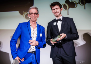 Two people pose at an awards ceremony