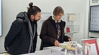 Die Visiting Professors aus Pforzheim in Changsha: Prof. Cosima Striepe und Stefan Barth blättern in hochschuleigenen Publikationen.