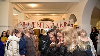 Gruppe mit Banner mit der Aufschrift "Neuentstehung"