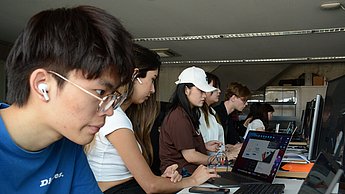 Mehrere Menschen sitzen jeweils an Computern
