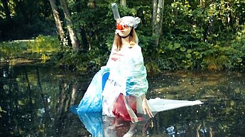 Eine Frau in einem Clownkostüm läuft durch einen See
