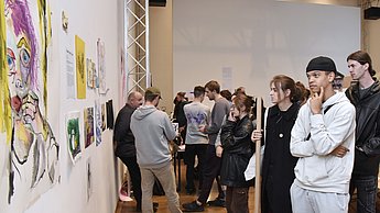 Personen betrachten aufgehängte Gemälde 