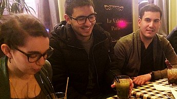 Drei Personen sitzen an einem Tisch