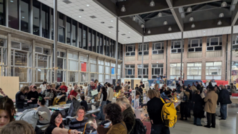 Personen stehen in einer Halle und unterhalten sich 