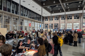 Personen stehen in einer Halle und unterhalten sich 