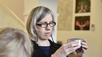 Frau betrachtet eine Metallform 