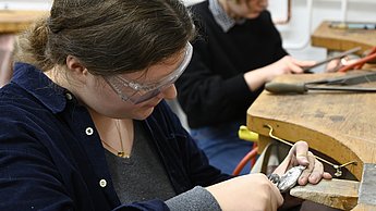 Studenten arbeiten an Werkbänken 