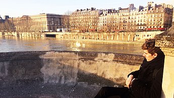 Person sitzt auf einer Brücke