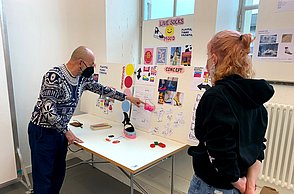 Personen betrachten eine Ausstellung 