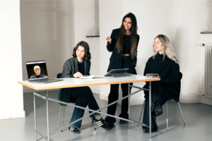 Students are showing off fashion on a laptop sitting on a table.