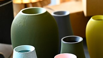 Verschiedene bunte Vasen in Zylinderform stehen eng beieinander