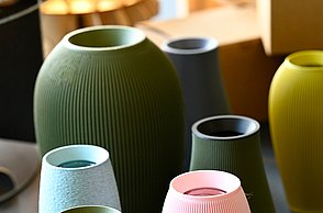 Verschiedene bunte Vasen in Zylinderform stehen eng beieinander