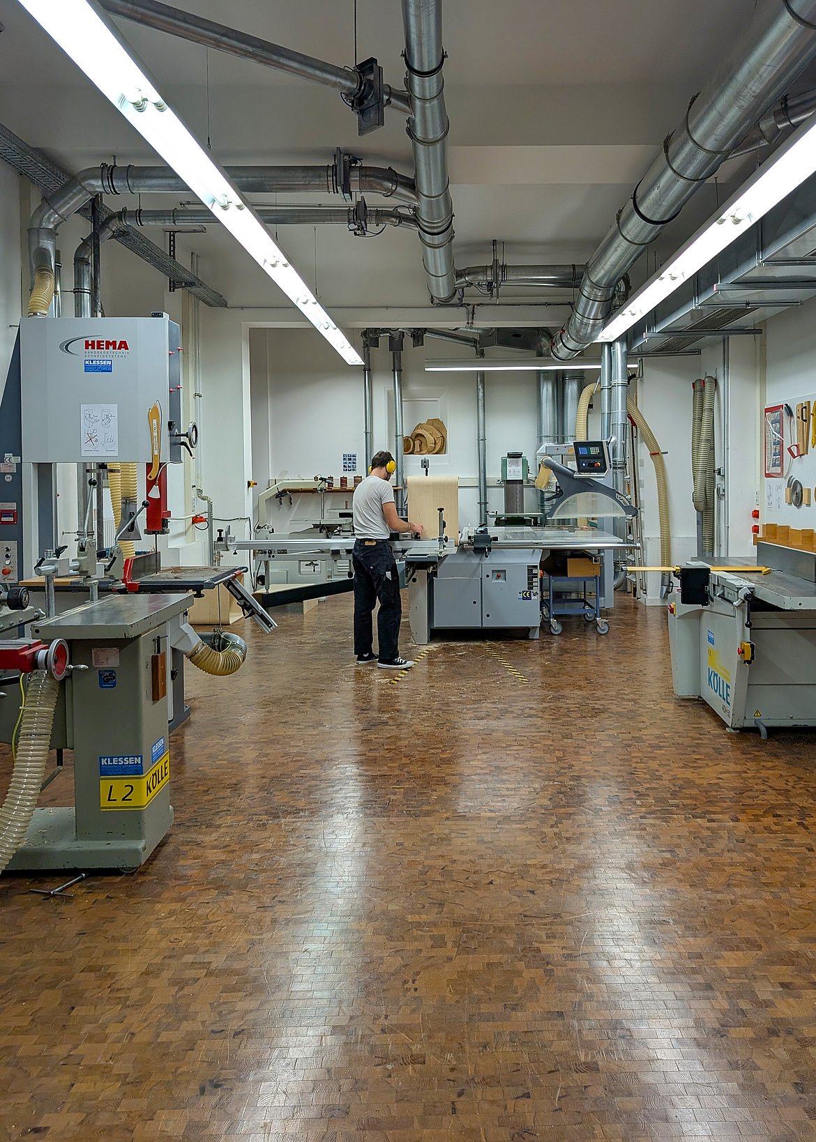 Bild Student an einer Maschine in der Schreinerwerkstatt