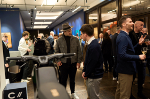 Foto einer Ausstellung bei welcher viele Menschen Objekte betrachten