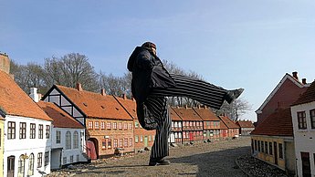 Foto einer großen Skulptur in mitten eines Dorfs