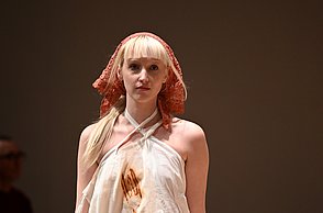 Model, welches ein weißes Kostüm trägt