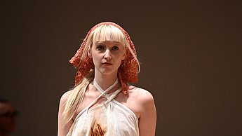 Model, welches ein weißes Kostüm trägt