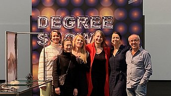 Gruppenfoto vor einer Leinwand