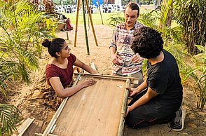 Personen sitzen um einen Tisch und reden