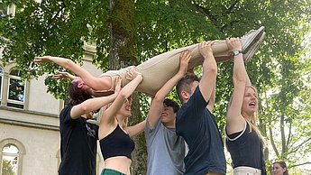 Gruppe hält eine Person hoch