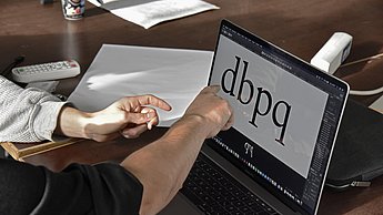 Zwei Personen betrachten Buchstaben auf einem Laptop