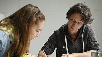 Studentin beobachtet jemanden beim zeichnen