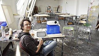 Student sitzt in einem Atelier und arbeitet