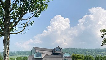 Bild einer grünen Landschaft und einem Haus in der Ferne