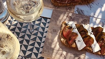Brotscheiben und Schüsseln stehen nebeneinander auf einem Holztisch