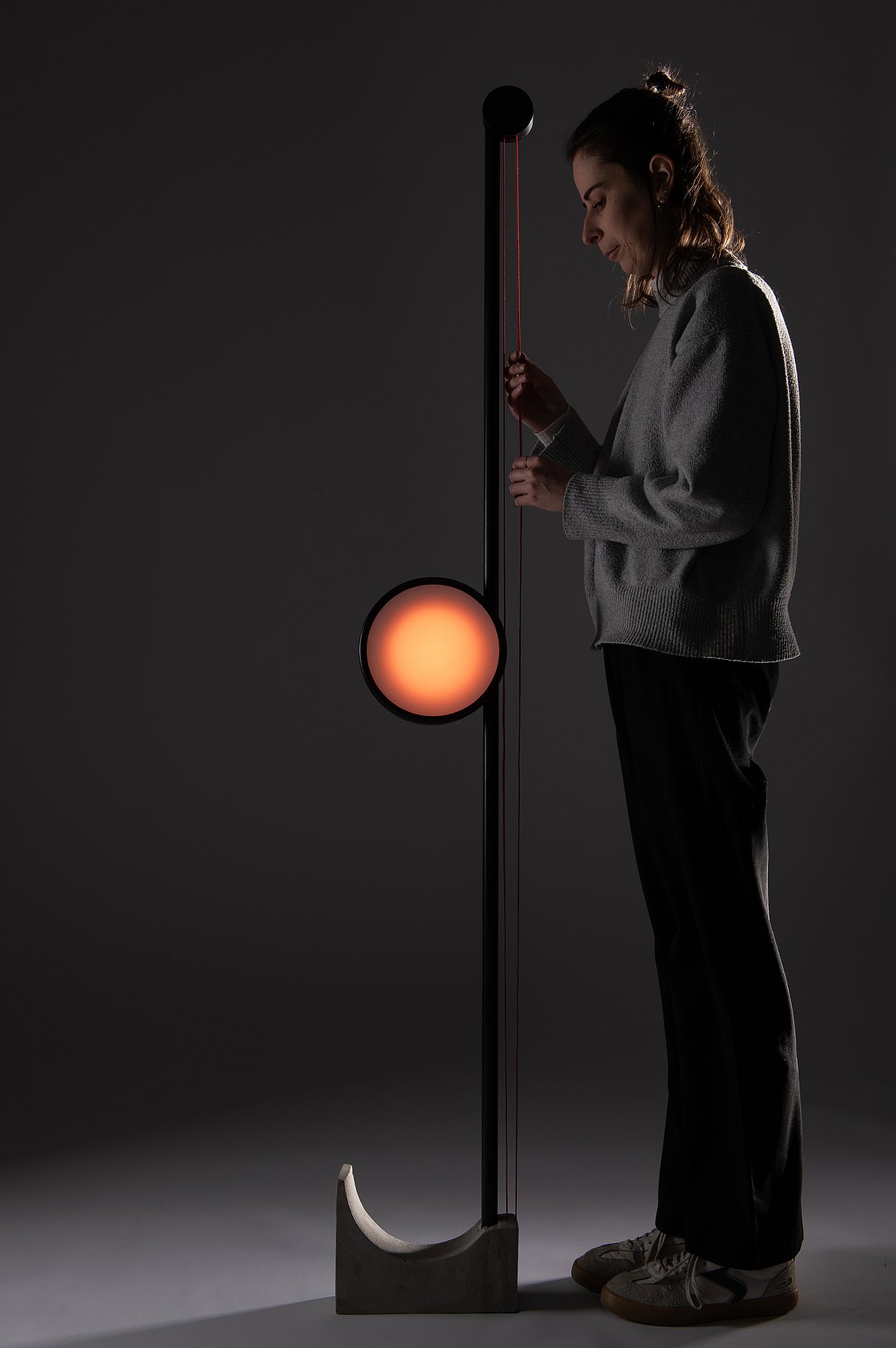 Dargestellt ist eine Person zusammen mit der entworfenen Standleuchte
