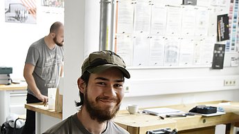 Mann sitzt an einer Werkbank