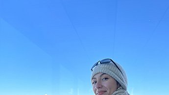 Person steht vor einer verschneiten Berglandschaft