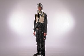 Dargestellt wird eine männliche Person mit dem entworfenen Schweißhelm und einer Weste mit den Düsen und Schläuchen.