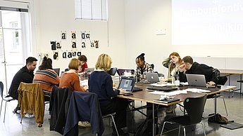 Gruppe sitzt an einem Tisch