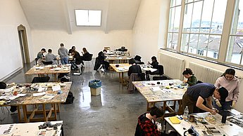 Studenten arbeiten an verschiedenen Tischen