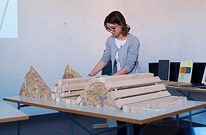 Studentin arbeitet mit Holzbalken