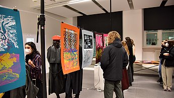 Personen betrachten bunte Plakate