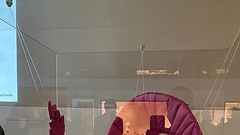 Skulpturen aus Papier hinter einer Glaswand