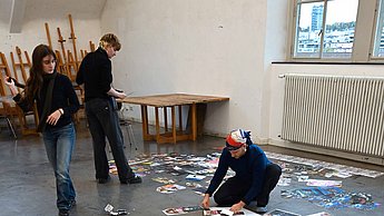 Verschiedene Bilder liegen auf dem Boden ausgelegt