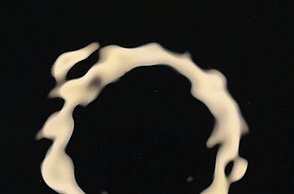 Foto einer Reflektion von einem Lichtkreis im schwarzen Wasser