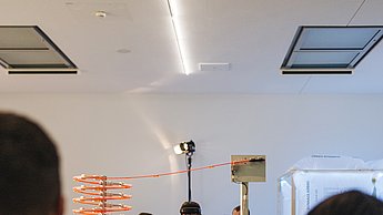Eine Ausstellung wird von Menschen betrachtet 
