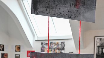 Foto einer Ausstellung mit gemalten Bildern mit Bleistift