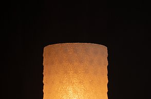 Dargestellt wird der 3D-gedruckte, zylinderförmige Lampenschirm mit runden Einkerbungen. 