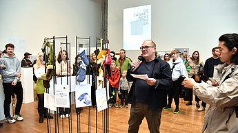 Mann stellt eine Ausstellung vor
