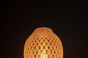 Dargestellt wird der 3D-gedruckte, ovale Lampenschirm mit runden Öffnungen. 