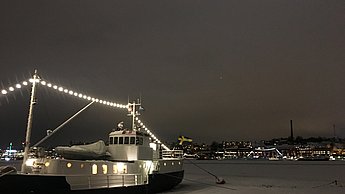 Schiff mit Lichterketten bei Nacht