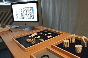 Foto eines Tisches mit verschiedenen, kleinen Holzmodellen 