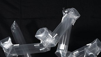 Foto einer langen Plastikfolie die auf schwarzem Hintergrund schwebt